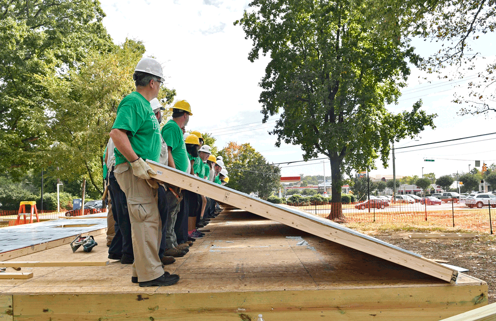 UNC Charlotte volunteers prepare to raise the first wall at the campus Habitat for Humanity build