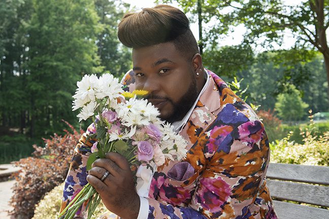 Lance holding a bouquet of flowers on campus