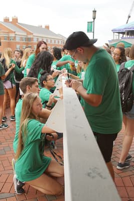 Students sign beam being placed in University Recreation Center