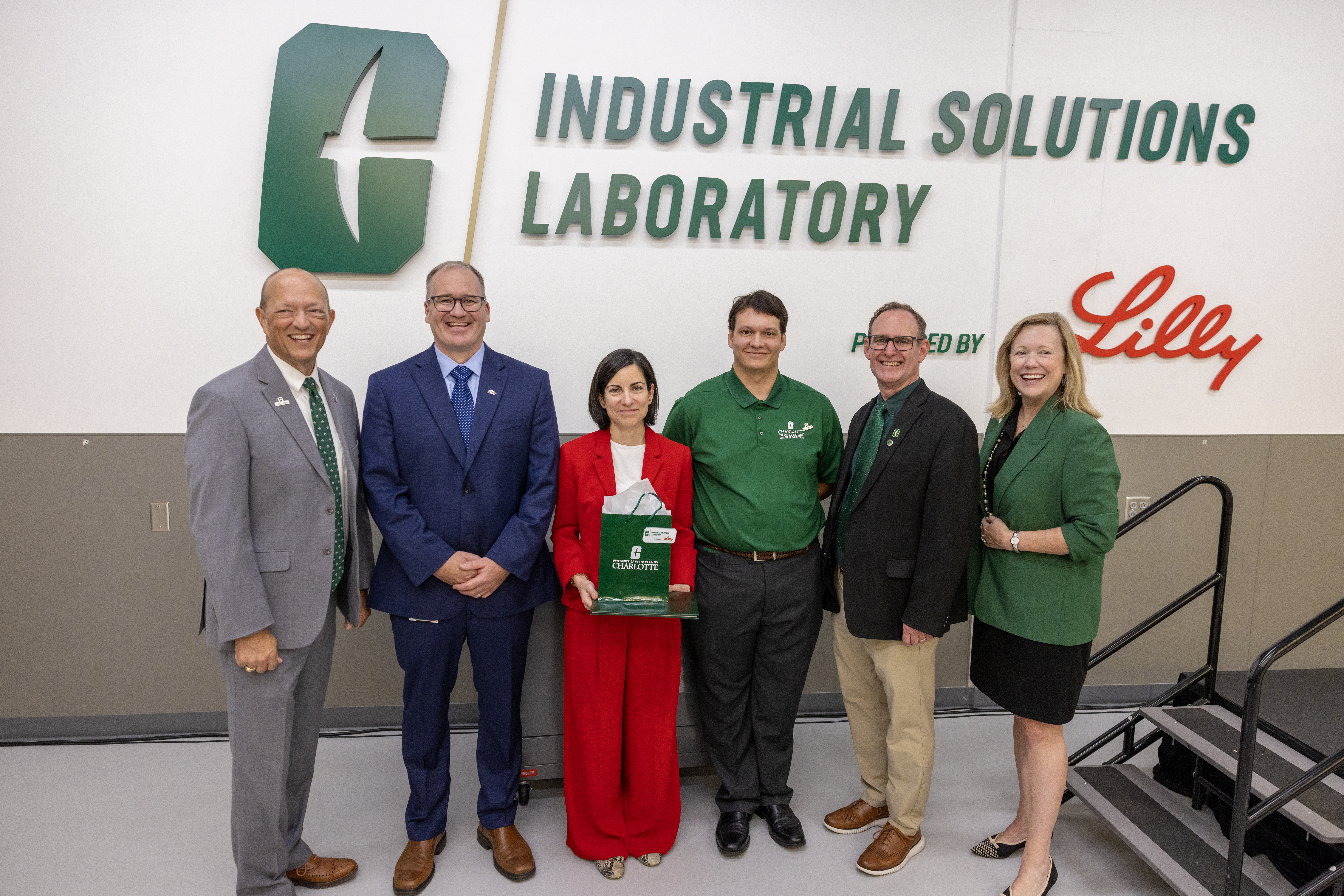 Group of six people standing in front of a wall with "Industrial Solutions Laboratory" text.